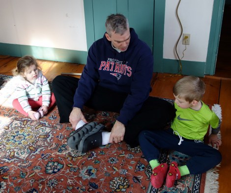 The kids help dad stretch out before a run.